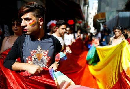 LGBT rights activists hold a rainbow flag during a transgender pride parade which was banned by the governorship, in central Istanbul, Turkey, June 19, 2016. REUTERS/Osman Orsal
