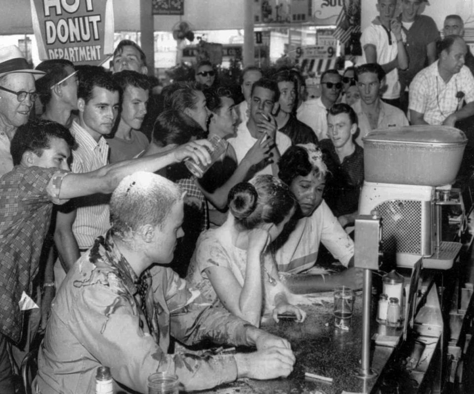 In this May 28, 1963, file photo, white people pour sugar, ketchup and mustard over heads of sit-in demonstrators at a Woolworth's lunch counter in Jackson, Miss.