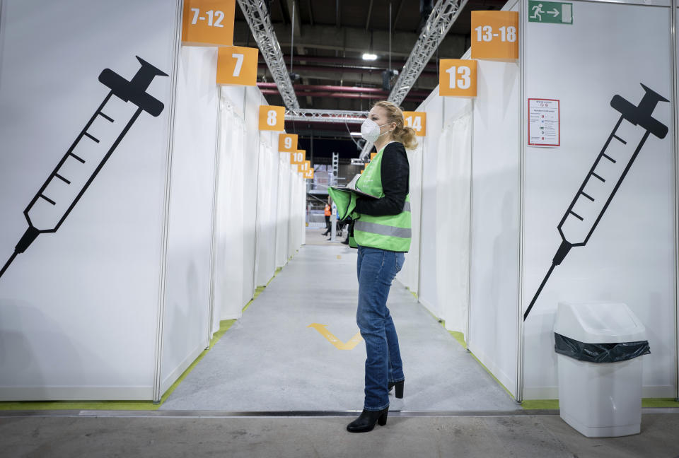 A volunteer stands inside the new open Erika-Hess-Eisstadion vaccine center in Berlin, Germany, Thursday, Jan. 14, 2021. (Kay Nietfeld/Pool vis AP)