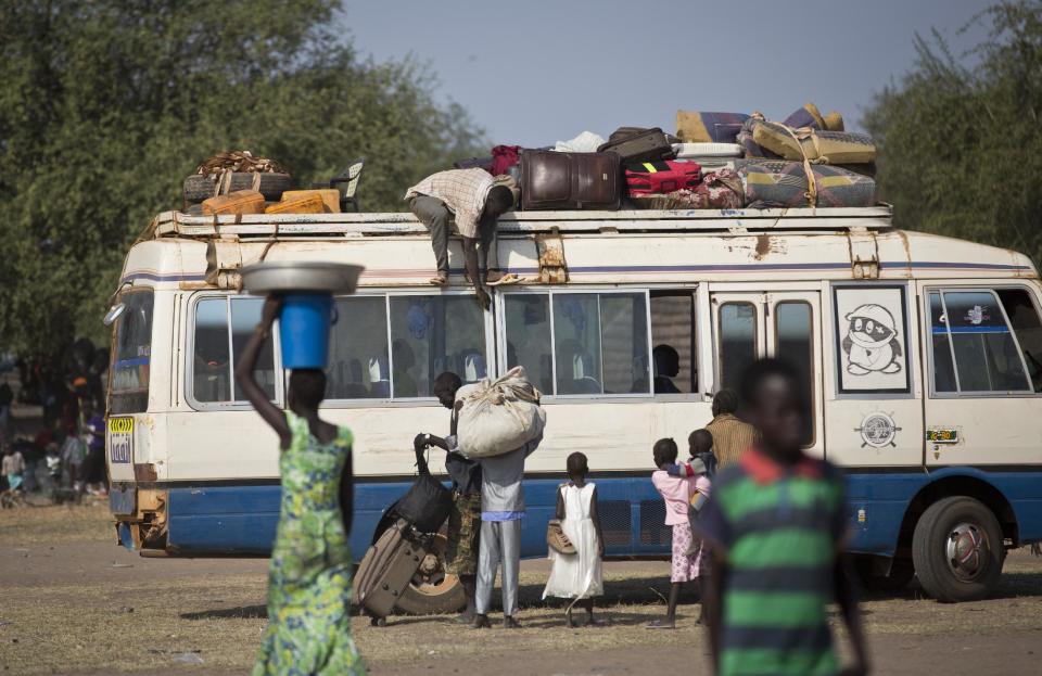 Those displaced who have enough money to pay the fare get on a bus heading to the capital Juba, some of the thousands who fled the recent fighting between government and rebel forces in Bor by boat across the White Nile, in the town of Awerial, South Sudan Thursday, Jan. 2, 2014. The international Red Cross said Wednesday that the road from Bor to the nearby Awerial area "is lined with thousands of people" waiting for boats so they could cross the Nile River and that the gathering of displaced is "is the largest single identified concentration of displaced people in the country so far". (AP Photo/Ben Curtis)