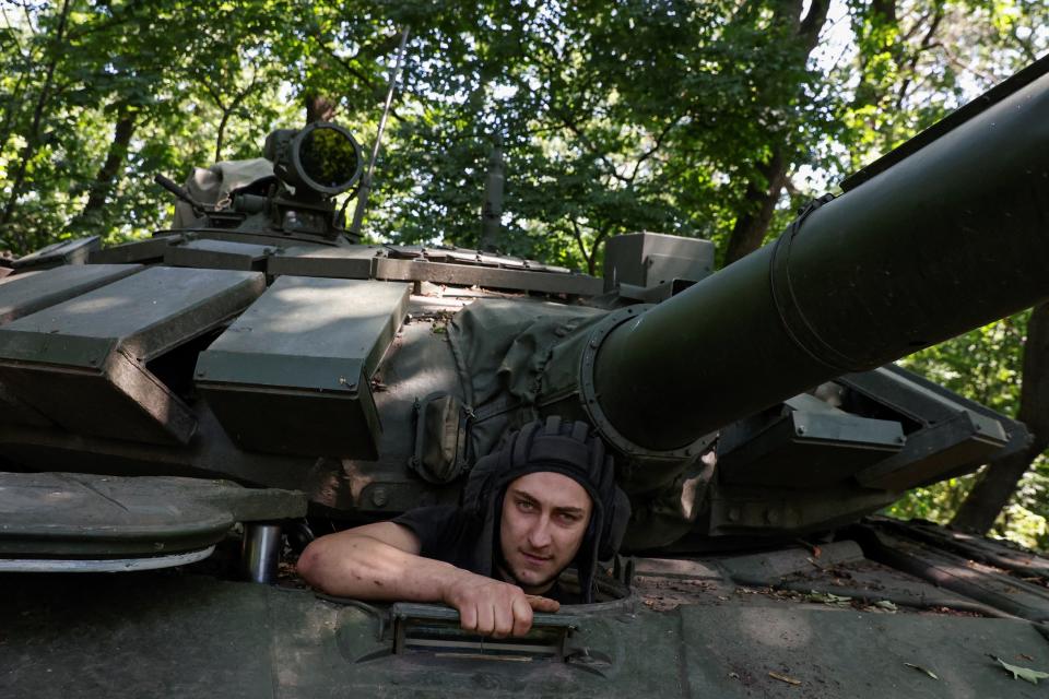 A Ukrainian serviceman of the 30th Kostiantyn Ostrozkyi Separate Mechanized Brigade takes a seat in a T-72 main battle tank captured earlier from Russian troops (REUTERS)