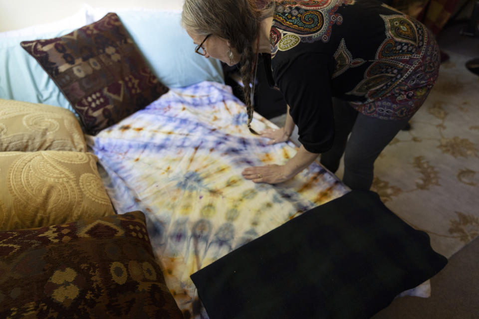 Cathy Jonas, owner of Epic Healing Eugene, Oregon’s first licensed psilocybin service center, adjusts a bed that can be used by clients Friday, Aug. 4, 2023, in Eugene, Ore. Epic Healing Eugene opened in June, marking the state’s unprecedented step in offering the mind-bending drug to the public. The center now has a waitlist of more than 3,000 names, including people with depression, PTSD or end-of-life dread. (AP Photo/Jenny Kane)