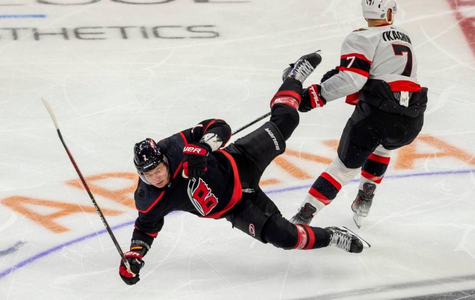 The Ottawa Senators Brady Tkachuk (7) checks the Carolina Hurricanes Dmitry Orlov (7) to the ice in the third period on Wednesday, October 11, 2023 at PNC Arena, in Raleigh N.C.