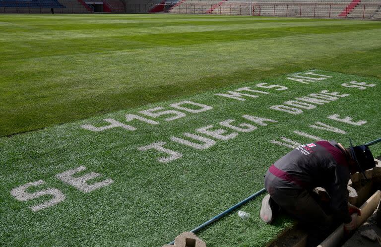 The field at the Municipal Villa Ingenio Stadium is covered with the Spanish phrase: 