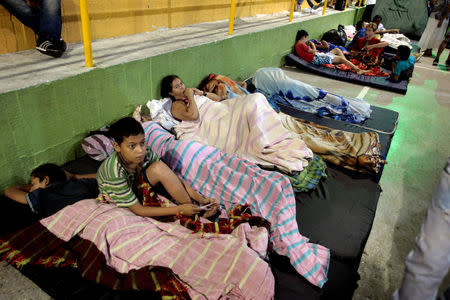 People rest on the floor of the municipal coliseum after the Colombian government ordered the evacuation of residents living along the Cauca river, as construction problems at a hydroelectric dam prompted fears of massive flooding, in Valdivia, Colombia May 17, 2018. REUTERS/Fredy Builes