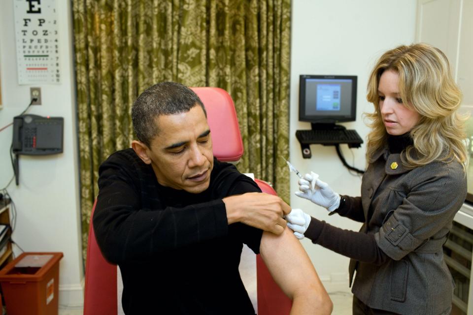 This photo taken Sunday, December 20, 2009, shows then-President Barack Obama at the White House Medical Unit as a White House nurse preparing to administer to him the H1N1 vaccine.