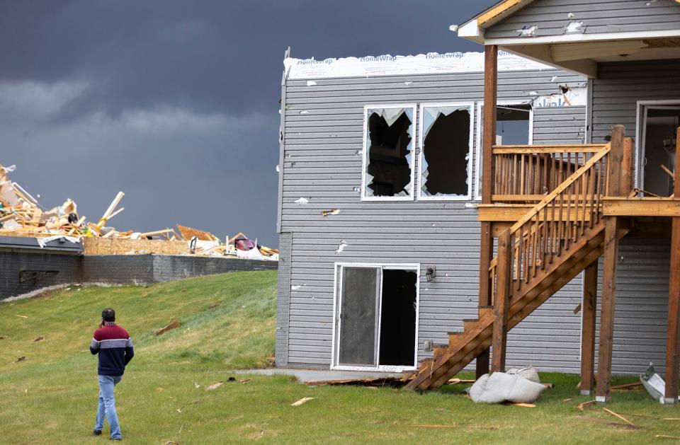 Gopala Penmetsa walks past a damaged house after a tornado passed through the area near Omaha, Neb., on Friday, April 26, 2024. His house was leveled by the tornado. (Chris Machian/Omaha World-Herald via AP)