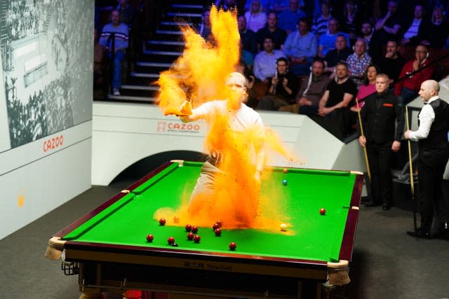 Just Stop Oil protester Eddie Whittingham jumping on the table during the match between Robert Milkins against Joe Perry during day three of the Cazoo World Snooker Championship at the Crucible Theatre in Sheffield on April 17 2023