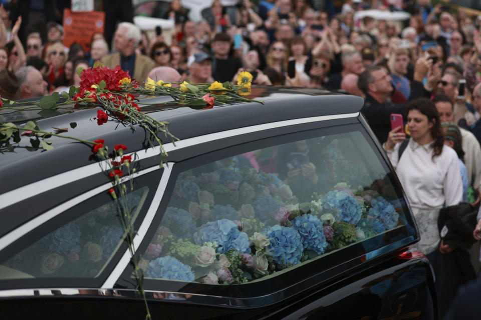 Fans de Sinéad O'Connor rodean su cortejo fúnebre en Bray, la ciudad natal de la cantante en el condado de Wicklow, Irlanda, el martes 8 de agosto de 2023. La familia de O'Connor invitó al público al paseo marítimo de Bray para despedirse de la artista. (Liam McBurney/ PA vía AP)