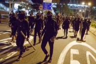 Protesters walk a street to clash with police in Tseung Kwan O in Hong Kong