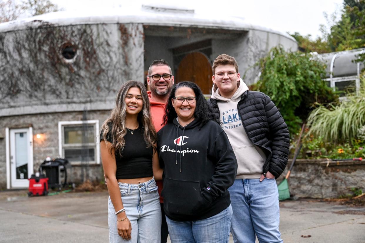 From left, Samantha Postema, her father Sam, Jennie Shire and her son Devin Shire pose outside the UFO-shaped home Sam and Jennie bought and are renovating on Wednesday, Sept. 27, 2023, in DeWitt Township.