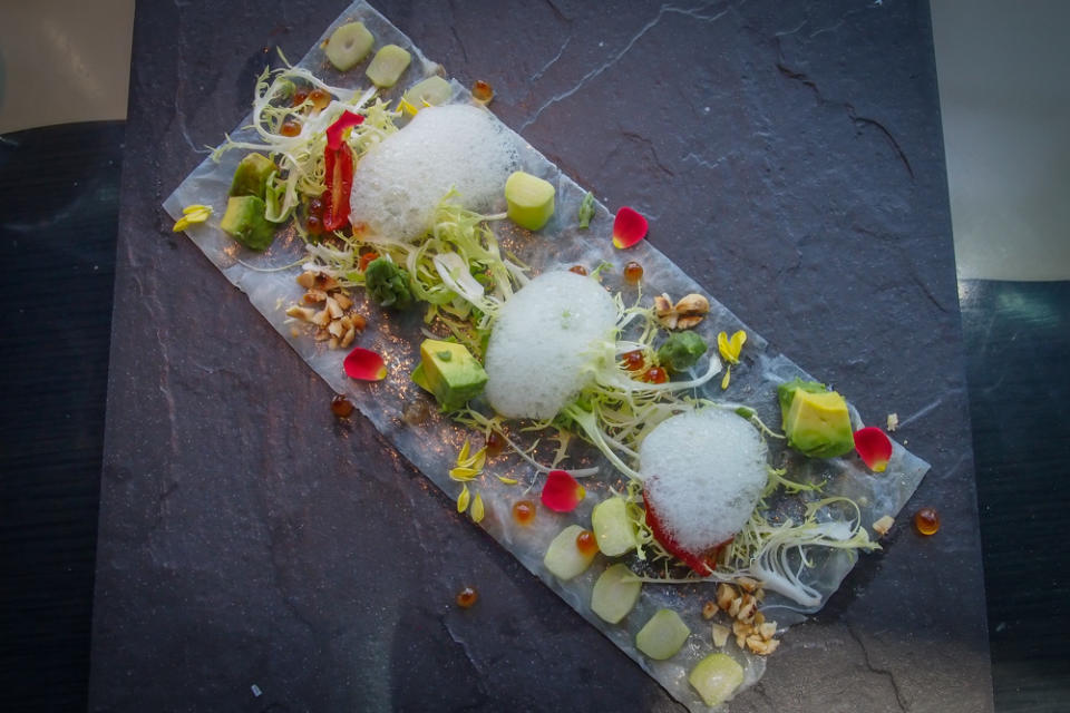 Painstakingly plated sea bass carpaccio, with lemon-infused foam, avocado, hazelnuts and asparagus.