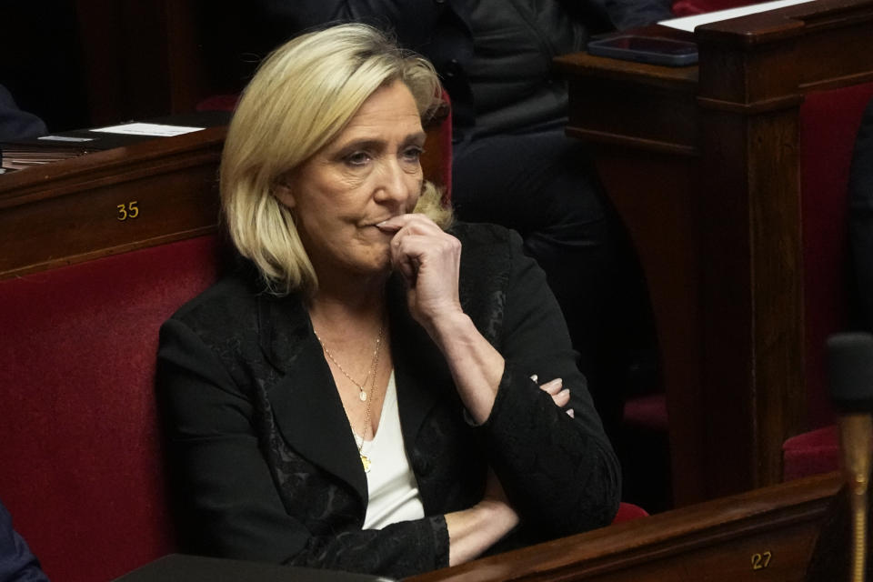 French far-right leader Marine Le Pen listens as French Interior Minister Gerald Darmanin delivers a speech at the French National Assembly in Paris, Monday, dec. 11, 2023. A divisive migration bill that would speed up deportations reaches the lower house of French parliament. (AP Photo/Michel Euler)