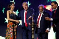 Republican presidential nominee Donald Trump (2nd L) enlists the help of Republican Hindu Coalition Chairman Shalli Kumar (2nd R) and others to light a ceremonial diya lamp before he speaks at a Bollywood-themed charity concert put on by the Republican Hindu Coalition in Edison, New Jersey, U.S. October 15, 2016. REUTERS/Jonathan Ernst