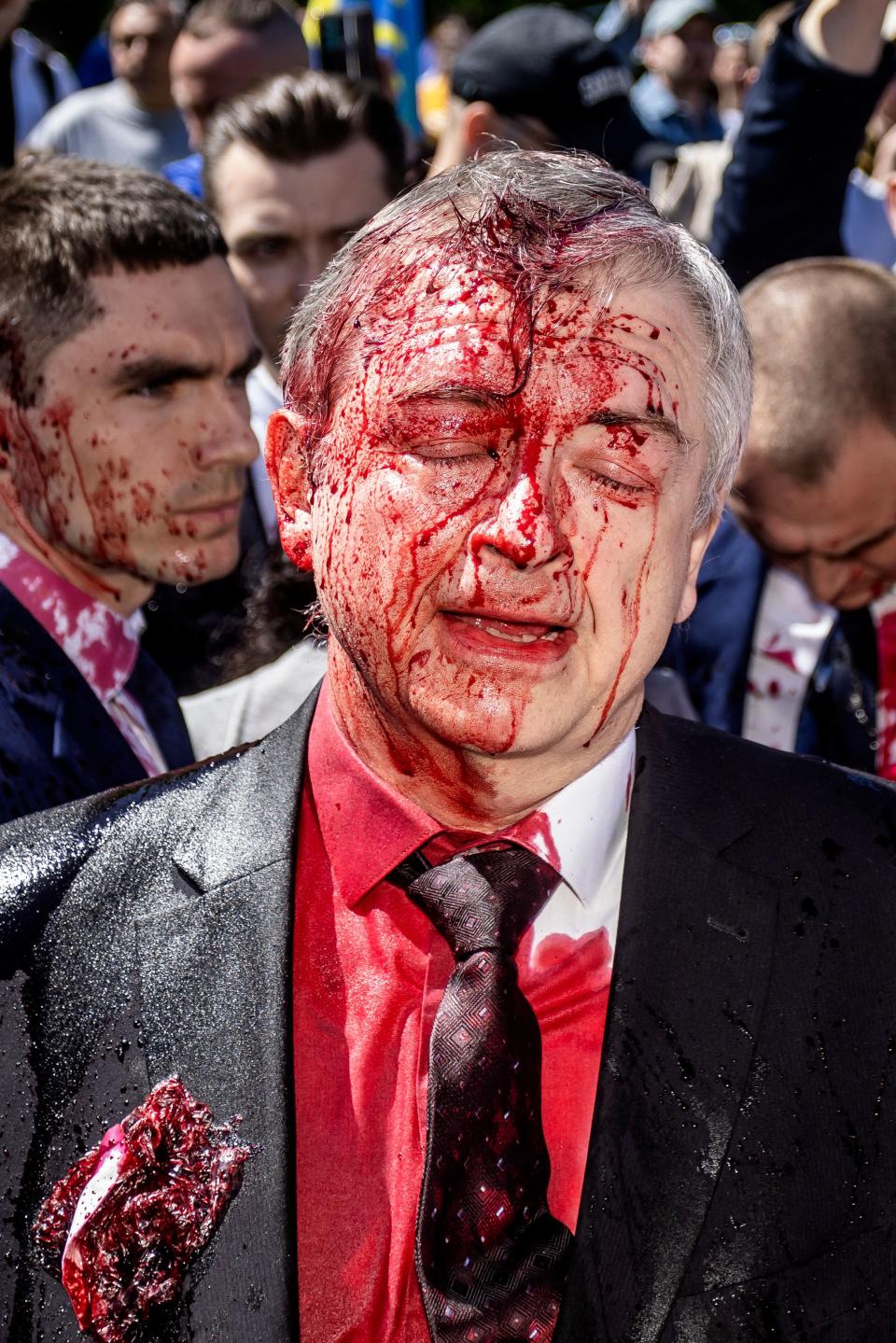 Sergey Andreev reacts after being covered with red paint during the protest.