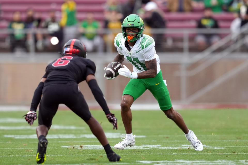 Oregon wide receiver Troy Franklin (11) runs after a catch against Stanford Cardinal cornerback Collin Wright (6) during the second quarter at Stanford Stadium Saturday, Sept. 30, 2023.