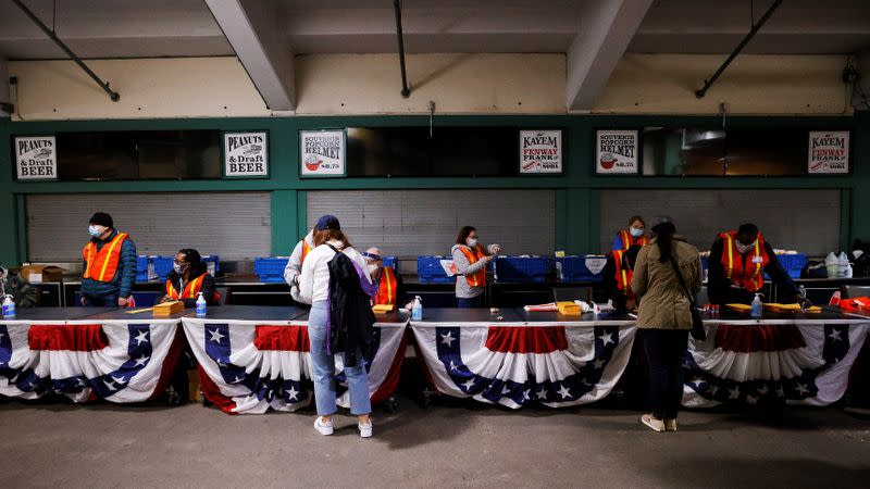 Voters pick up their ballots at Fenway Park on the first day of early voting in Boston