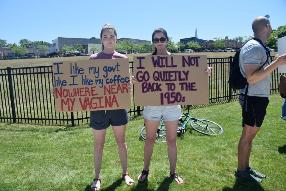 Kaitlin Arteaga, left and Madison Yenglin, right, hold up their signs during a pro-abortion rights rally along US-31, in front of the hole in downtown Petoskey on Sunday, July 3.