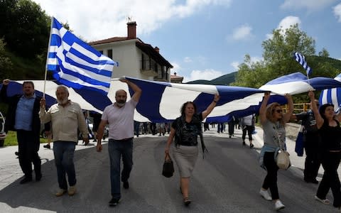 Protesters carried a giant Greek national flag during a demonstration against the agreement - Credit:  ALEXANDROS AVRAMIDIS/ REUTERS