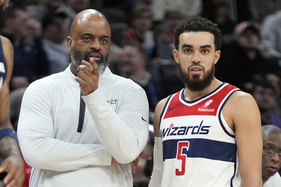 Washington Wizards head coach Wes Unseld Jr. talks with guard Tyus Jones (5) during the first half of an NBA basketball game against the Minnesota Timberwolves, Wednesday, Jan. 24, 2024, in Washington. (AP Photo/Mark Schiefelbein)