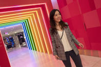 Yoli Ho poses for photos at the entrance to Story on its opening day at Macy's, Wednesday, April 10, 2019, in New York. A year after buying startup Story, Macy's is bringing to life the retail concept to 36 stores in 15 states including its Manhattan flagship store. (AP Photo/Mark Lennihan)