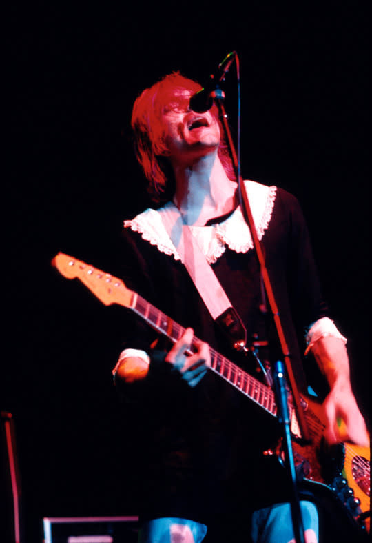 Kurt Cobain wears a mini dress dress on stage.