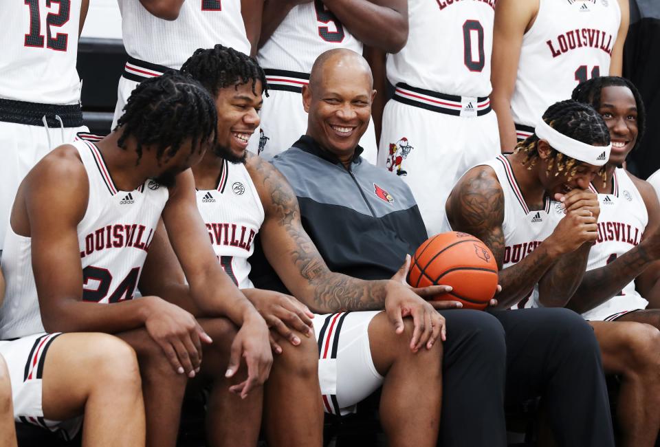 U of L Head Basketball Coach Kenny Payne, center, shared a chuckle with Sydney Curry (21) as they gathered for an official team portrait on media day at the Kueber Center practice facility in Louisville, Ky. on Oct. 20, 2022.  