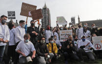 Hospitality workers protest in Parliament Square in London, Monday, Oct. 19, 2020. Hospitality workers are demonstrating outside Parliament against tougher coronavirus restrictions and the amount of financial support given by the government to the industry.(AP Photo/Frank Augstein)