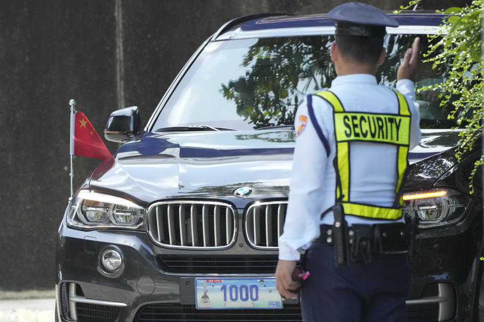 A security guard signals to a car with diplomatic plates and Chinese flag as he parks at the Philippine Department of Foreign Affairs in Manila, Philippines on Monday, Aug. 7, 2023. The Philippine government summoned the Chinese ambassador on Monday to convey a diplomatic protest over the Chinese coast guard's use of a water cannon against a Filipino supply boat in the disputed South China Sea, a Philippine official said. (AP Photo/Aaron Favila)