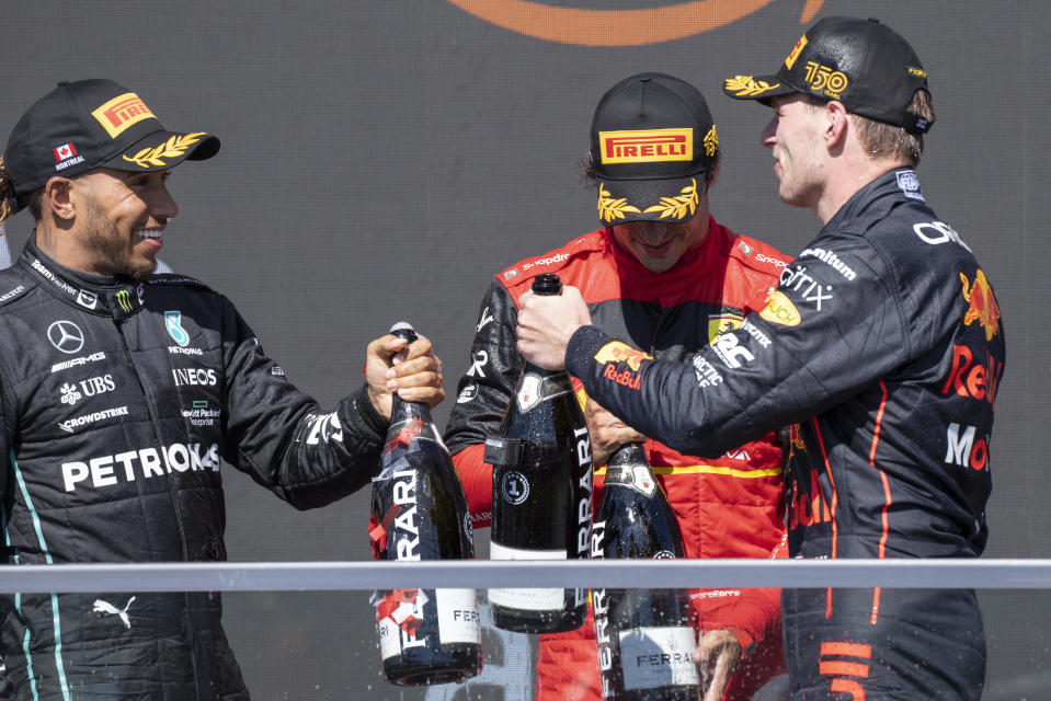 Winner Red Bull Racing Max Verstappen, of the Netherlands, shares the podium with Scuderia Ferrari Carlos Sainz, left, of Spain, and third place Mercedes Team Lewis Hamilton, right, of Great Britain during victory ceremonies at the Canadian Grand Prix in Montreal on Sunday, June 19, 2022. (Paul Chiasson/The Canadian Press via AP)