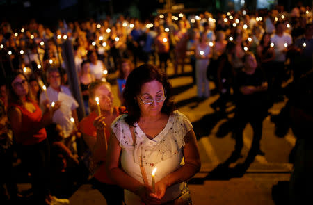 Relative and friends of victims of a collapsed tailings dam owned by Brazilian mining company Vale SA, carry candles as they pay respects during a vigil in Brumadinho, Brazil January 31, 2019. REUTERS/Adriano Machado