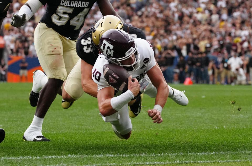 Texas A&M backup quarterback Zach Calzada fumbles the ball while being tackled at the goal line by Colorado linebacker Joshka Gustav.