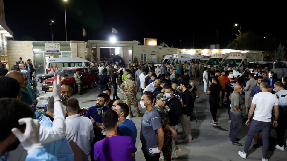 People gather outside a hospital in Iraq's Nineveh province on Wednesday, where survivors of the blaze are being treated. - Khalid Al-Mousily/Reuters