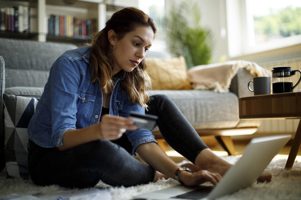 a woman on her laptop holding a credit card