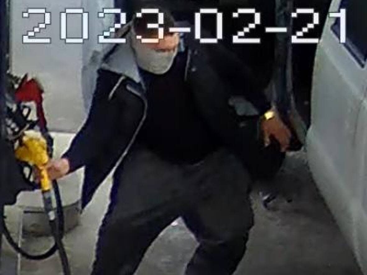 A security camera photo of a man allegedly stealing gas from a station in Milton on Feb. 21. Police say this man and a second man are also suspects in a carjacking and hit and runs in the region. (Halton Regional Police Service - image credit)