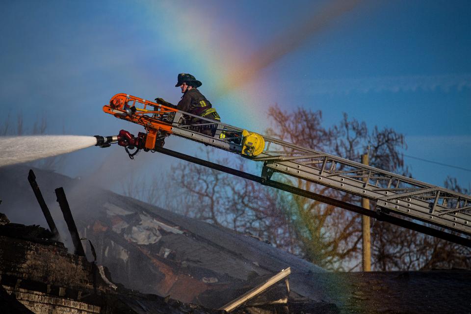 Louisville firefighters spray the smoldering remains of a strip mall at the corner of 18th and W. Jefferson street after an overnight fire destroyed the building early Wednesday morning. Dec. 21, 2022