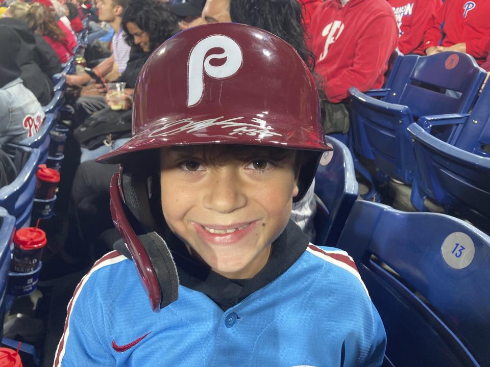 Hayden Dorfman, 10, of Voorhees, N.J., wears Philadelphia Phillies slugger Bryce Harper’s autographed helmet during a baseball game against the Pittsburgh Pirates, Thursday, Sept. 28, 2023, in Philadelphia. Harper tossed his helmet into the stands after he was ejected and it was retrieved by Dorfman. (AP Photo/Daniel Gelston)