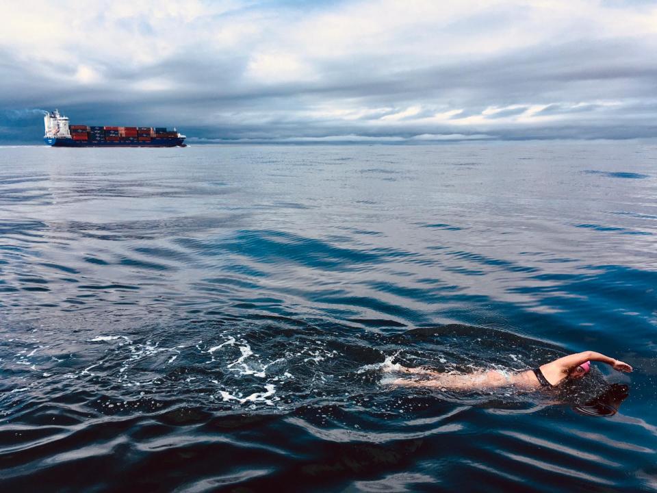 Morton native Bethany Mitchell swims across the North Channel, with a cargo ship making the trip as well, on July 27, 2023 in Ireland.