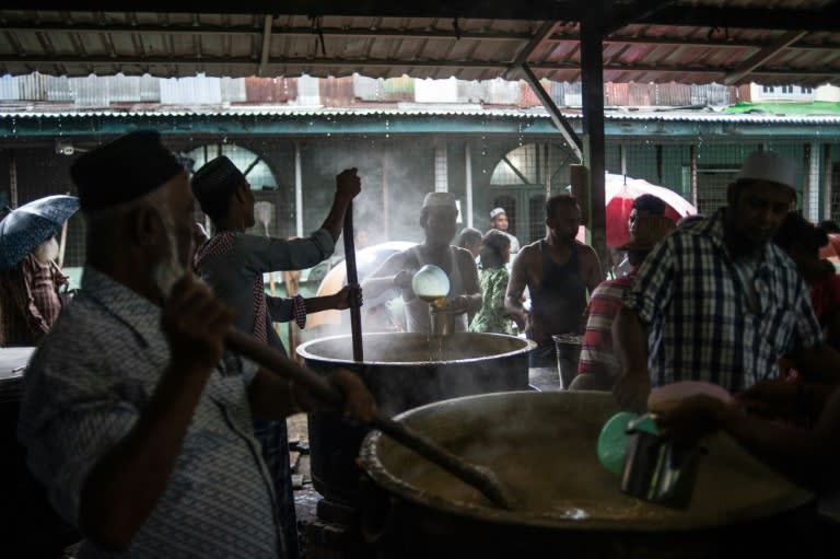 Men stir huge steaming vats of daal as they prepare to feed members of the Muslim community in Yangon when they break their fast during the holy month of Ramadan