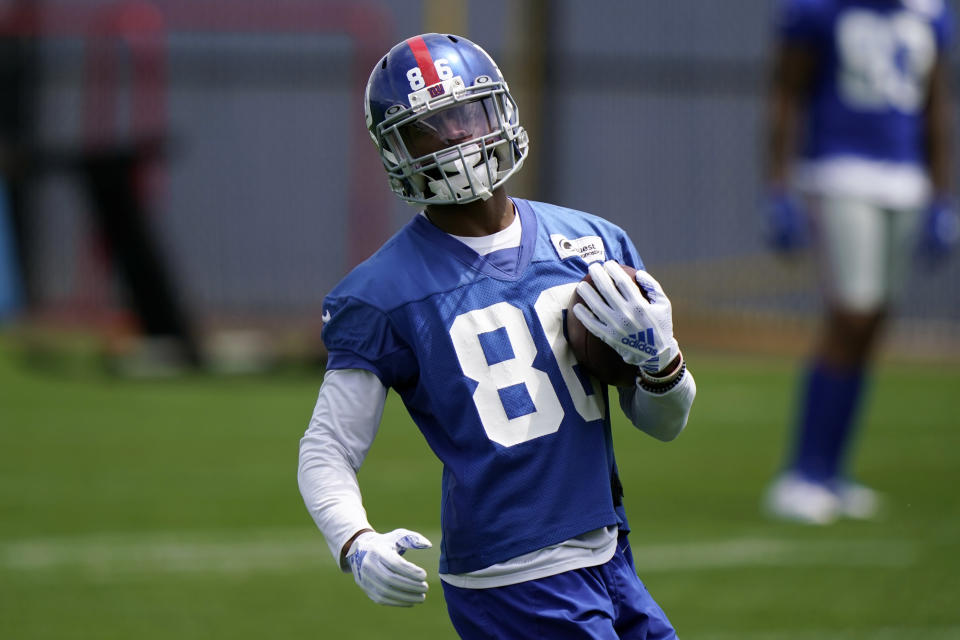 New York Giants wide receiver Darius Slayton (86) carries the ball after catching a pass from quarterback Daniel Jones during an NFL football practice, Thursday, June 10, 2021, in East Rutherford, N.J. (AP Photo/Kathy Willens)