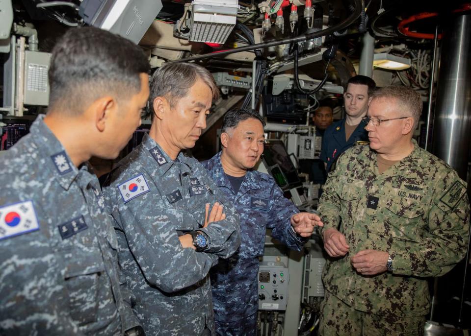 Japan Maritime Self-Defense Force Vice Adm. Tateki Tawara, commander, Fleet Submarine Force, third from the left; speaks with U.S. Navy Rear Adm. Rick Seif, commander, Submarine Group 7, right,; Republic of Korea (ROK) Navy Rear Adm. Su Youl Lee, commander, Submarine Force, second from left; and ROK Navy Lt. Cmdr. Dongkeon Oh, executive officer of ROK Navy submarine ROKS SON WON IL (SS-072), left; during an underway embark aboard USS Maine, in vicinity of Guam on April 18.
