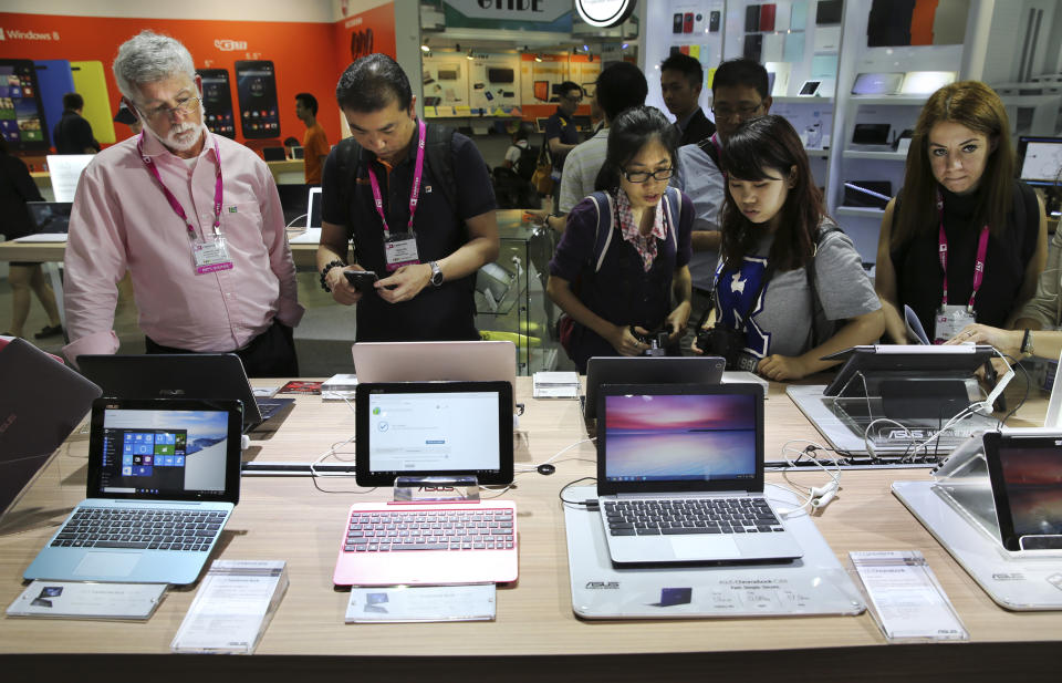 FILE - Visitors review new Asus computer products at the Computex trade show in Taipei, Taiwan, Tuesday, June 2, 2015. The U.S. government has announced talks with Taiwan, Thursday, Aug. 18, 2022, on a trade treaty in a new sign of support for the self-ruled island democracy claimed by China’s ruling Communist Party as part of its territory. (AP Photo/Wally Santana, File)