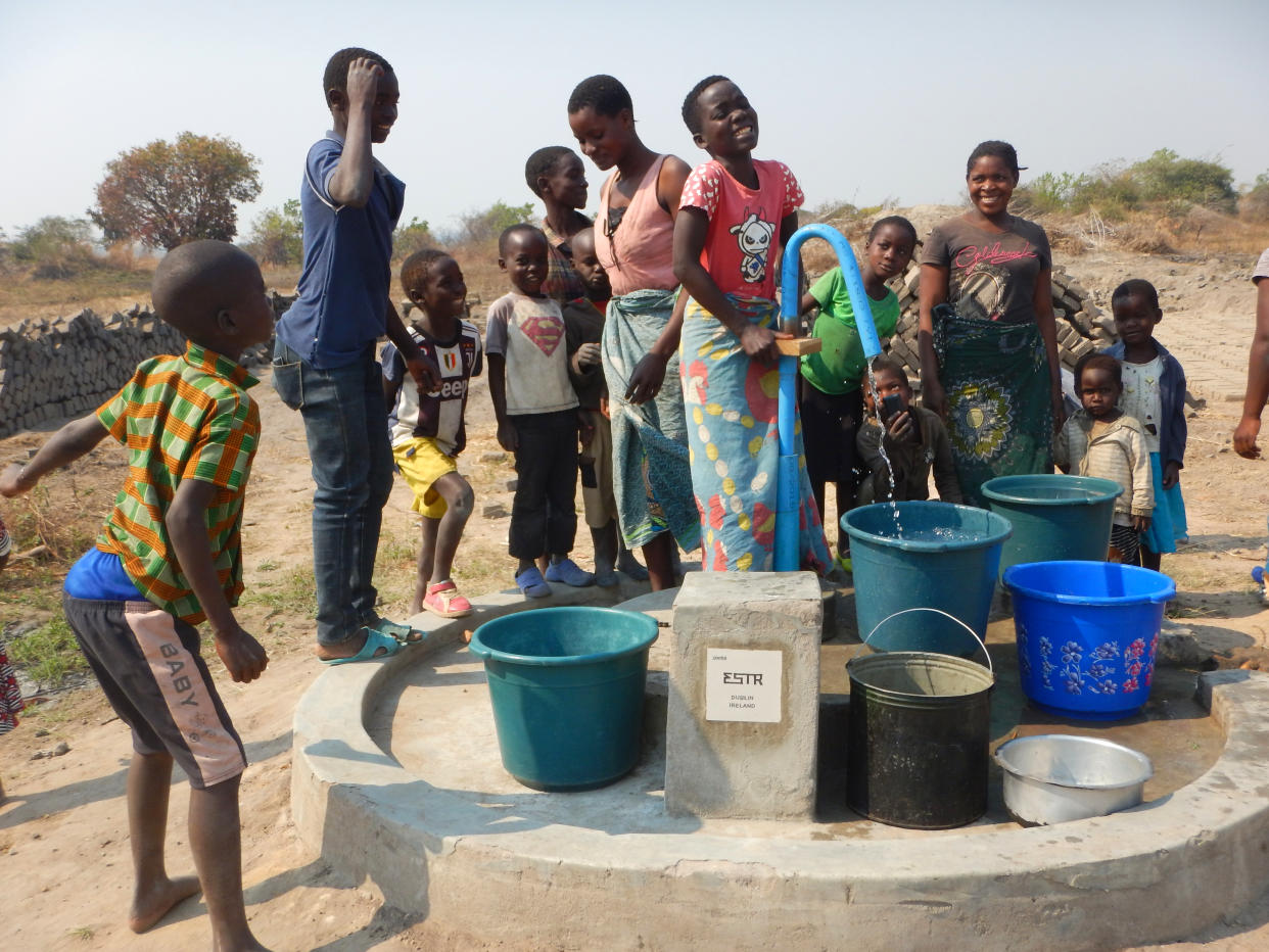 Members of a community in Northern Malawi gather around a water pump installed with assistance from the Wells for Zoë charity. (Wells for Zoë/Flickr)