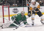 Dallas Stars goaltender Jake Oettinger (29) defends the goal against Pittsburgh Penguins center Jeff Carter (77) during the second period of an NHL hockey game in Dallas, Saturday, Jan. 8, 2022. (AP Photo/LM Otero)