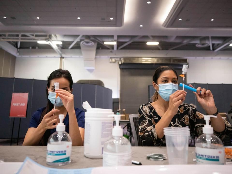 A COVID-19 vaccination clinic at the Vancouver Convention Centre in Vancouver in January 2022. Canada's national vaccination advisory body is calling for high-risk individuals to get another COVID-19 booster shot, starting this spring. (Ben Nelms/CBC - image credit)