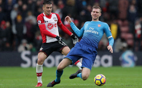 Dusan Tadic of Southampton tackles Per Mertesacker of Arsenal - Credit: Richard Heathcote/Getty Images