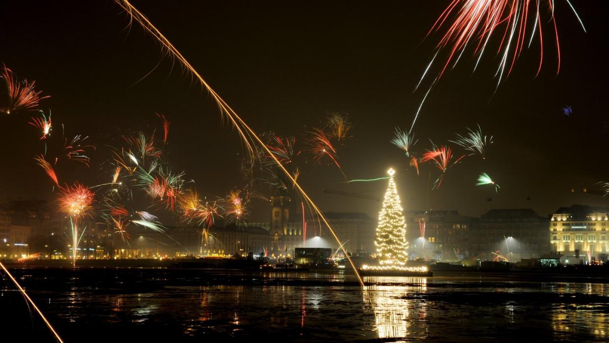 Silvesterraketen erleuchten den Himmel über der Binnenalster in Hamburg.