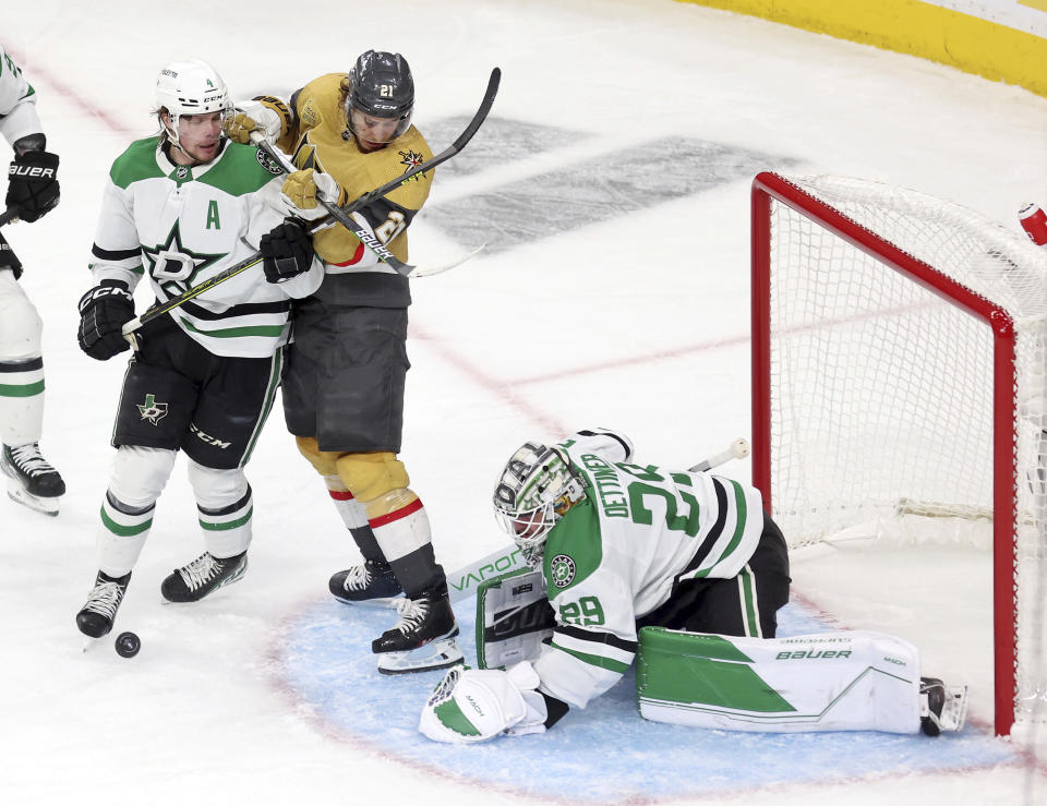 Dallas Stars goaltender Jake Oettinger (29) blocks a shot near Vegas Golden Knights center Brett Howden (21) during the second period in Game 5 of the NHL hockey Stanley Cup Western Conference finals Saturday, May 27, 2023, in Las Vegas. (AP Photo/Ronda Churchill)