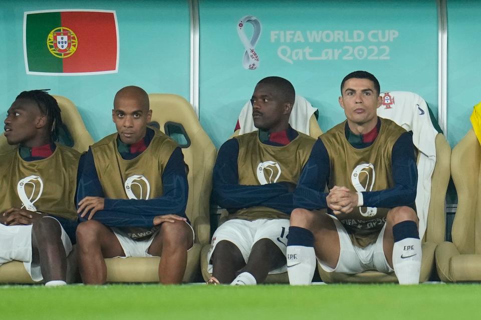 Portugal's Cristiano Ronaldo, right, sits on the bench during the World Cup quarterfinal soccer match against Morocco.