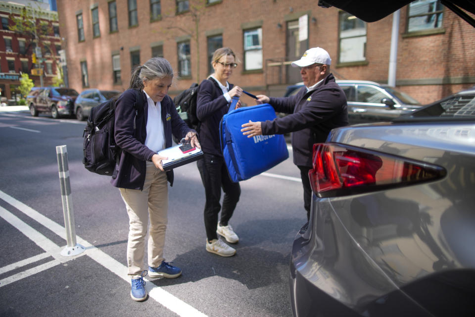 Dr. Amy Attas, left, and licensed veterinary technician Jeanine Lunz, center arrive at a clients apartment building, Tuesday, April 23, 2024, in New York. (AP Photo/Mary Altaffer)